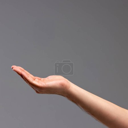 Foto de Mano femenina mostrando gesto sobre fondo gris. Jugando con gestos, haciendo figuras con palmas. Bajo gesto de lluvia. Concepto de relación humana, comunidad, simbolismo, cultura - Imagen libre de derechos