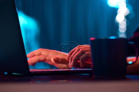Businessman working remotely, typing on laptop keyboard over neon lights. Working with online projects. Concept of business, modern technologies, occupation, career development, internet Poster 655845396
