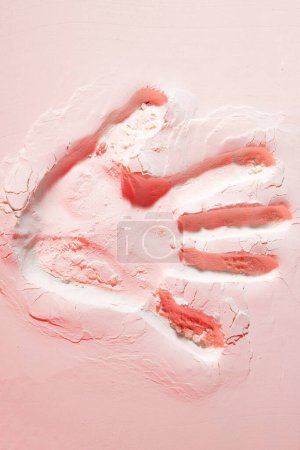 Téléchargez les photos : Fond créatif et magnifique de papier peint avec une empreinte de main vive sur une belle plage de sable rose. Photographie d'art créative. Nature abstraite. Conception, bannière, affiche - en image libre de droit