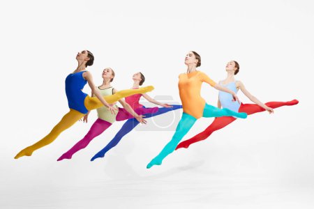 Photo for Jumping, flying. Tender female ballet dancers in colorful tights and bodysuits, dancing against grey studio background. Concept of beauty, creativity, classic dance style, elegance, contemporary art - Royalty Free Image