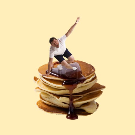 Photo for Man sliding on delicious pancakes with jam over yellow background. Carbohydrates food. Contemporary art collage. Concept of food, creativity, sweets, taste, unhealthy habbits. Modern design - Royalty Free Image
