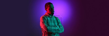 Photo for Portrait of man in checkered shirt posing with thoughtful, serious face against pink gradient studio background in neon light. Concept of human emotions, facial expression, lifestyle. Banner - Royalty Free Image