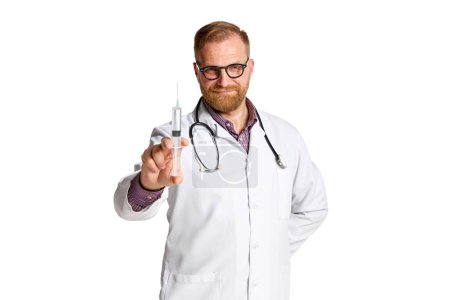 Photo for Bearded mature man in glasses, lab coat and stethoscope, doctor holding syringe with meds isolated over white background. Concept of medicine, occupational, healthcare, profession, treatment - Royalty Free Image
