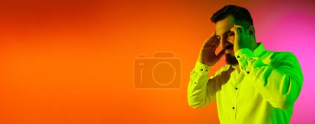 Photo for Portrait of bearded man in casual clothes posing with thoughtful face against gradient studio background in neon light. Banner. Concept of human emotions, facial expression, lifestyle, business - Royalty Free Image