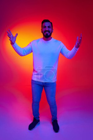 Photo for Full-length portrait of handsome bearded man smiling, laughing, posing with positive mood against gradient studio background in neon light. Concept of human emotions, facial expression, lifestyle - Royalty Free Image