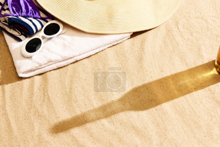 Foto de Sombra de botella de cerveza sobre arena tibia. Texturizado. Chile de playa en el cálido día de verano con bebida fresca, refresco y relajación. Concepto de bebida alcohólica, sabor, vacaciones de verano, vacaciones, cervecería. Anuncio - Imagen libre de derechos