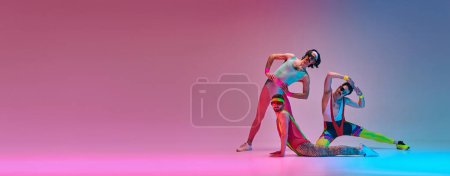 Photo for Flexible men in colorful, vintage sportswear stretching against gradient blue pink studio background in neon light. Sportive and active lifestyle, humor, retro style concept. Banner. Copy space for ad - Royalty Free Image