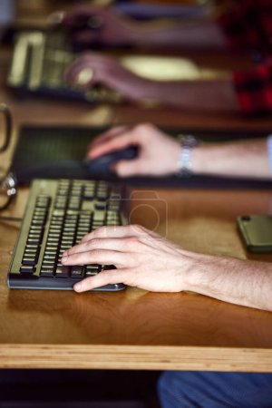 Foto de Imagen de cerca de manos masculinas, tecleando en el teclado de la computadora, sentado en la mesa y trabajando en la oficina. Concepto de ocupación creativa, negocio, profesión, estilo de vida de oficina. Antecedentes no enfocados - Imagen libre de derechos
