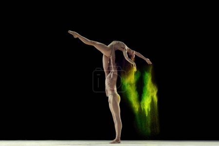 Photo for Attractive, talented, young man and woman, ballet dancers making colorful performance with powder explosion over black studio background. Concept of art, festival, beauty of dance, inspiration, youth - Royalty Free Image