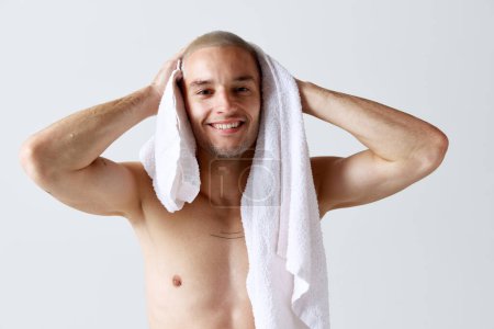 Photo for Morning shower routine. Handsome young shirtless man washing body and face against white studio background. Concept of mens beauty, skincare, cosmetology, spa, health. Copy space for ad - Royalty Free Image