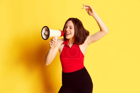 Photo for Activist. Young girl emotionally shouting in megaphone against yellow studio background. Social movements, information. Concept of youth, human emotions, lifestyle, ad. Freedom of speech - Royalty Free Image
