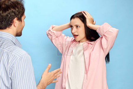 Photo for Man talking with woman expressing shocked emotions against blue studio background. Amazement, unexpected news. Concept of friendship, relationship, communication, emotions, lifestyle, ad - Royalty Free Image
