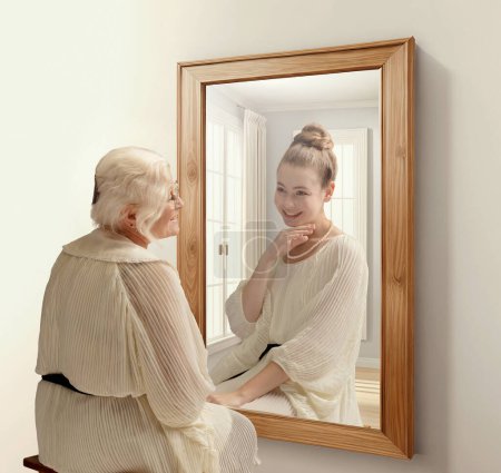 Photo for Creative conceptual collage. Smiling senior woman looking in mirror and remembering her past. Young girl in reflection. Concept of present, past and future, age, lifestyle, memories, generation, ad - Royalty Free Image
