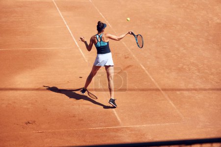 Foto de Vista superior de la imagen de la mujer joven, jugador de tenis en movimiento durante el juego en la cancha de tenis al aire libre. Sesión de entrenamiento. Concepto de deporte, hobby, estilo de vida activo, salud, resistencia y fuerza, ad - Imagen libre de derechos