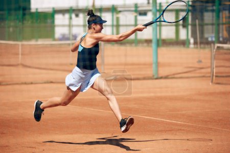 Téléchargez les photos : Image dynamique de l'athlète professionnel, joueur de tennis en mouvement pendant le jeu, l'entraînement à l'extérieur par une chaude journée ensoleillée. Concept de sport, passe-temps, mode de vie actif, santé, endurance et force, publicité - en image libre de droit
