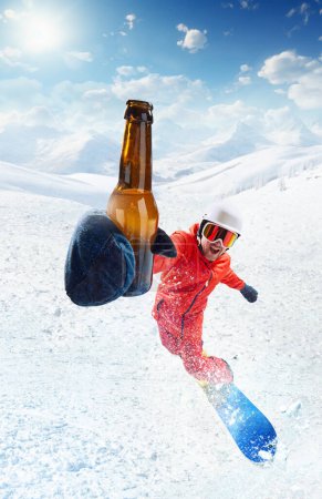 Photo for Cheers. Smiling man in uniform and helmet riding on snowboard with beer bottle. Snowy background, blue sunny sky. Winter sport, action, motion, hobby, leisure time concept. Banner. Copy space for ad - Royalty Free Image