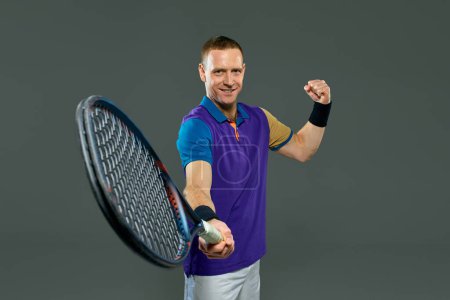 Photo for Man, professional tennis player posing with racket isolated over grey background. Winner, champion. Concept of professional sport, action and motion, health., strength, competition, ad - Royalty Free Image