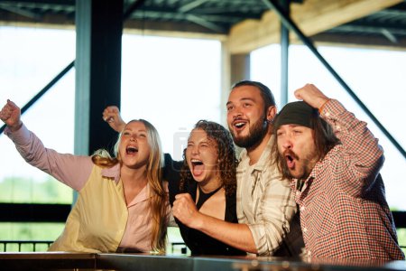 Photo for Group of young people, friends, sport fans attending pub to watch football match in cheer up favourite team. Concept of sport competition, hobby, lifestyle, human emotions, fun - Royalty Free Image