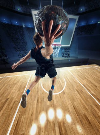 Photo for Winner. Top view image of muscular man, basketball player in motion during match, jumping, throwing ball into basket. 3D stadium. Concept of professional sport, competition, action, hobby, game. - Royalty Free Image