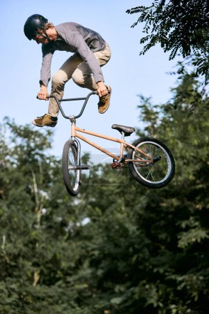 Foto de Imagen dinámica de cuerpo entero del joven que monta bicicleta deportiva, bmx. Saltar alto, hacer trucos, entrenar en el parque. Concepto de estilo de vida activo, deporte, extremo, dinámica, hobby - Imagen libre de derechos