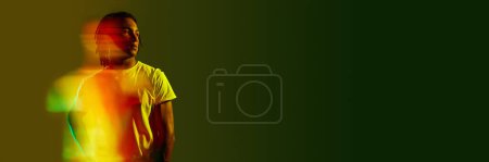 Photo for Inner self. Creative portrait of handsome young guy with neon filter reflection on gradient green background. Mixed light effect. Concept of art, fashion, modern style, cyberpunk, futurism, ad. Banner - Royalty Free Image