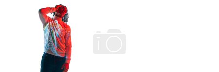 Foto de Surrealismo. Joven africano con colorido filtro de neón rayas reflexión sobre el cuerpo posando sobre fondo blanco en luz de neón. Concepto de arte, moda, estilo moderno, cyberpunk, futurismo, anuncio. Banner - Imagen libre de derechos