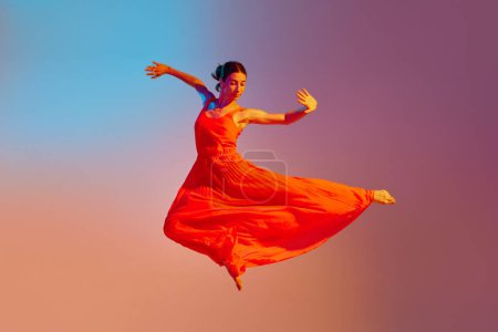 Photo for Dynamic image of young talented, artist woman in elegant red dress dancing against gradient multicolored background in neon light. Concept of modern dance style, hobby, art, performance, lifestyle, ad - Royalty Free Image