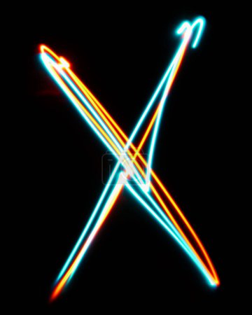 Foto de Letra X del alfabeto hecha de signo de neón. La imagen de luz roja azul, larga exposición con luces de hadas de colores, sobre un fondo negro. Concepto de diseño - Imagen libre de derechos