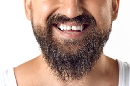 Photo for Cropped image of male face, beard and white teeth against white studio background. Taking care after beard. Concept of mens beauty, skin care, cosmetology, health and wellness. Copy space for ad - Royalty Free Image