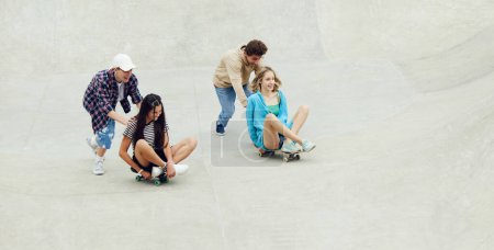 Photo for Group of cheerful friends, teens spending good time together on skatepark, skateboarding, laughing. Joy. Concept of youth culture, sport, dynamic, extreme, hobby, action and motion, friendship - Royalty Free Image