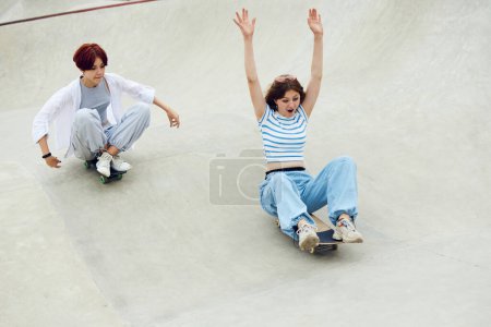 Foto de Chicas adolescentes felices y alegres, patinaje en el parque de skate, divertirse y relajarse con amigos. Concepto de cultura juvenil, deporte, dinámica, extrema, afición, acción y movimiento, amistad - Imagen libre de derechos
