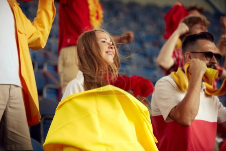 Téléchargez les photos : Une jeune femme souriante assiste à un match de football, encourageant son équipe de football préférée. Un match gagnant. Concept de sport, coupe, monde, équipe, événement, compétition, émotions, championnat et paris - en image libre de droit
