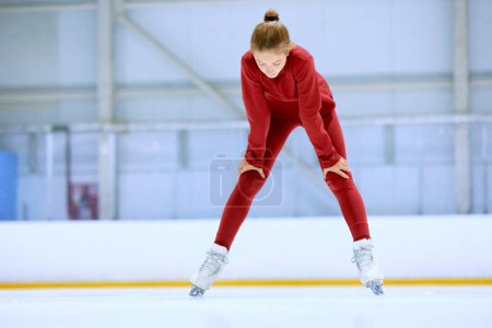 Photo for Girl in red sportswear, figure skating athlete standing on ice rink area and resting after hard training. Concept of professional sport, competition, sport school, health, hobby, ad - Royalty Free Image