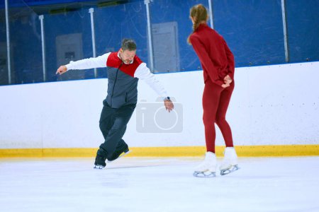 Photo for Professional skater, man training girl, learning figure skating activity on ice rink arena. Sport lessons with coach. Concept of professional sport, competition, sport school, health, hobby, ad - Royalty Free Image