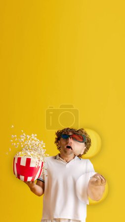 Photo for Mature emotive man in 3D glasses, with popcorn basket, watching impressive movie against yellow studio background. Concept of emotions, facial expression, lifestyle, leisure time, ad - Royalty Free Image