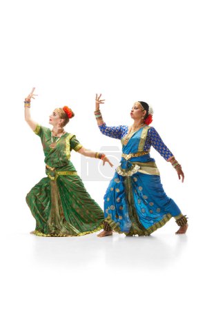 Téléchargez les photos : Sattriya danse. Femmes, dans de belles robes indiennes traditionnelles dansant sur fond de studio blanc. Concept de beauté, mode, Inde, traditions, mode de vie, chorégraphie, art. Publicité - en image libre de droit