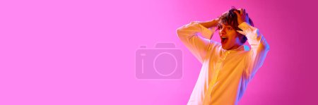 Photo for Big sales. Young emotional woman holding head with hand and excited face on pink studio background in neon lights. Concept of emotions, facial expression, youth, lifestyle. Banner. Copy space for ad - Royalty Free Image
