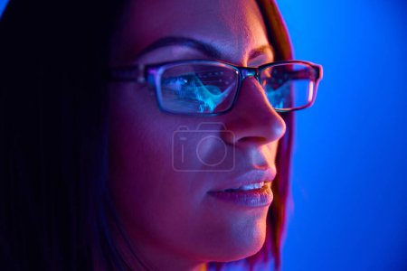 Foto de Primer plano de la mujer enfocada en gafas mirando la pantalla de la computadora, analizando gráficos del mercado de valores. Reflejo de gafas. Concepto de negocio, mercado comercial, finanzas, emociones, juventud, estilo de vida. Anuncio - Imagen libre de derechos