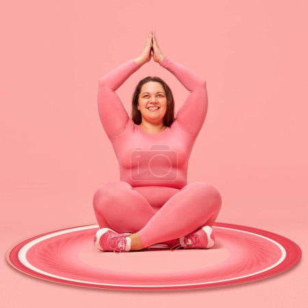 Téléchargez les photos : Jeune femme en surpoids positive assise dans une posture de yoga, s'entraînant sur fond rose avec des éléments abstraits. Collage d'art contemporain. Concept de sport, créativité, action et mouvement. Design créatif - en image libre de droit