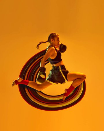 Photo for Leg kick. Sportive teen girl, mma athlete in motion, training over orange background with abstract design element. Contemporary art collage. Concept of sport, action and motion, health - Royalty Free Image