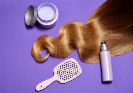 Photo for Wavy blonde hair with healthy glow over purple background. Using hair mask, brush and spray conditioner. Concept of hair care, organic products, natural beauty, cosmetics. Ad. Poster. - Royalty Free Image