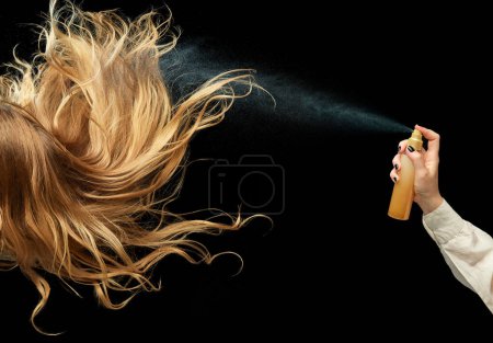 Foto de Cabello rubio sano y hermoso sobre fondo negro. Pulverización acondicionador del cabello para la fuerza y el brillo. Concepto de cuidado del cabello, productos orgánicos, belleza natural, cosméticos. Anuncio. Cartel. - Imagen libre de derechos