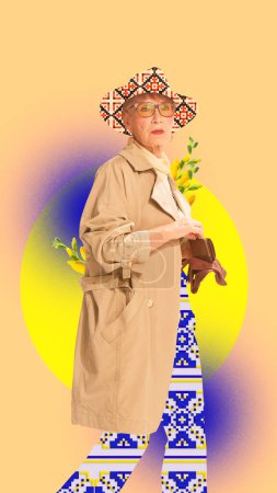 Foto de Elegante mujer mayor con elegante gabardina, sombrero un pantalón con diseño de adorno sobre fondo amarillo. collage de arte contemporáneo. Concepto de cultura, tradiciones, diversidad, nacionalidad, creatividad - Imagen libre de derechos