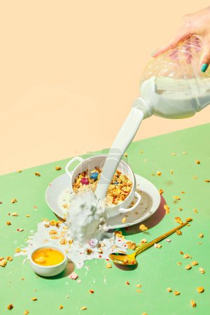 Photo for Female hand pouring milk into bowl with muesli, cereal with berries against pastel background. Overflow of milk. Concept of healthy food, nutrition, pop art style, taste. Poster. Copy space for ad - Royalty Free Image