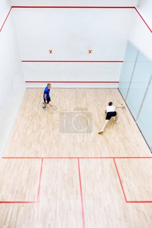Photo for Top view of two young men, friends, sportsmen playing squash on squash court. Competition. Concept of sport, hobby, healthy and active lifestyle, game, gym, ad - Royalty Free Image