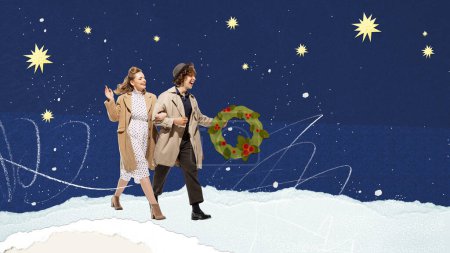 Photo for Young happy couple, man and woman cheerfully walking with wreath over blue sky background with stars. Contemporary art. Winter season, holidays, Christmas, celebration concept. Design for ad, postcard - Royalty Free Image