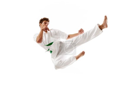 Photo for Flying kicks. Professional martial arts athlete, karateka in white kimono training, practicing isolated on white studio background. Concept of martial arts, combat sport, energy, strength, health. Ad - Royalty Free Image