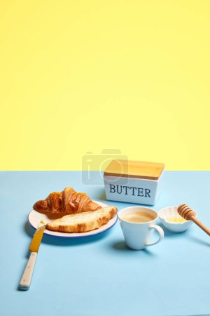 Photo for Delicious breakfast with croissant, butter, honey and cup with freshly made coffee, espresso over blue yellow background. Concept of food, bakery, breakfast ideas, freshness. Poser. Copy space for ad - Royalty Free Image