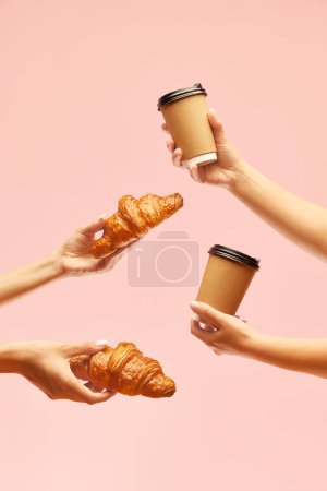 Photo for Breakfast for two. Human hands holding croissants and coffee cups to go over pink background. Concept of food, bakery, breakfast ideas, taste, freshness. Poser. Copy space for ad - Royalty Free Image