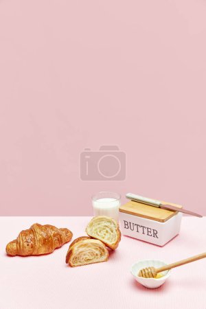 Photo for Delicious breakfast. Freshly baked crispy croissants with butter and honey isolated over pink background. Concept of food, bakery, breakfast ideas, taste, freshness. Poser. Copy space for ad - Royalty Free Image